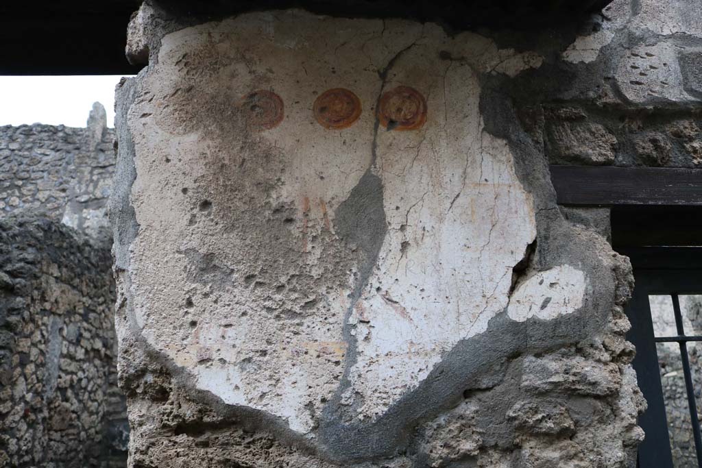II.1.13 Pompeii. December 2018. Painted plaster on exterior wall, on north side (left) of entrance. Photo courtesy of Aude Durand.

