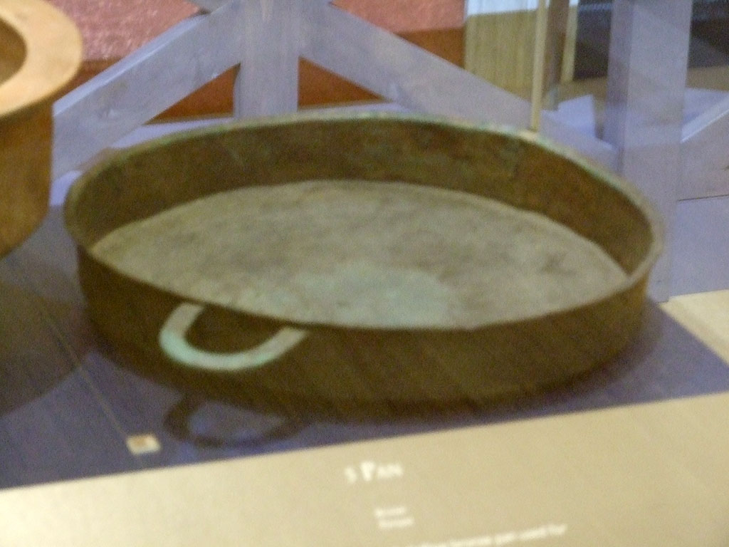 II.9.2 Pompeii. Bronze tegame or pan. SAP 12738. 
Photographed at �A Day in Pompeii� exhibition at Melbourne Museum. September 2009.

Two bronze statuettes of Apollo and Fortuna with cornucopia and a clay herm of a child Dionysus with panther were also found still in situ in the household lararium.
See Attivit� della Soprintendenza: Regio II, Insula 9: Rivista di Studi Pompeiani II, 1988, p. 200.
