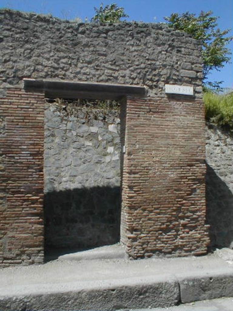 III.1.6 Pompeii. May 2005. Entrance doorway, partly excavated
According to Della Corte, an obscure Praedicinius practiced his unknown commerce or industry here.
He came to this conclusion because of the graffito found on the pilaster on the right -
Popidium adulescentem
Praedicinius rog(at) aed(ilem)    [CIL IV 7608]
See Della Corte, M., 1965.  Case ed Abitanti di Pompei. Napoli: Fausto Fiorentino. (p.342)
According to Garcia y Garcia, there was slight damage to the south-east corner of this insula, when a bomb fell onto the Via dell�Abbondanza in 1943. The bomb fell in front of the SE corner of this insula, between III.1.6 and I.XI.7.  See Garcia y Garcia, L., 2006. Danni di guerra a Pompei. Rome: L�Erma di Bretschneider. (p.51)

