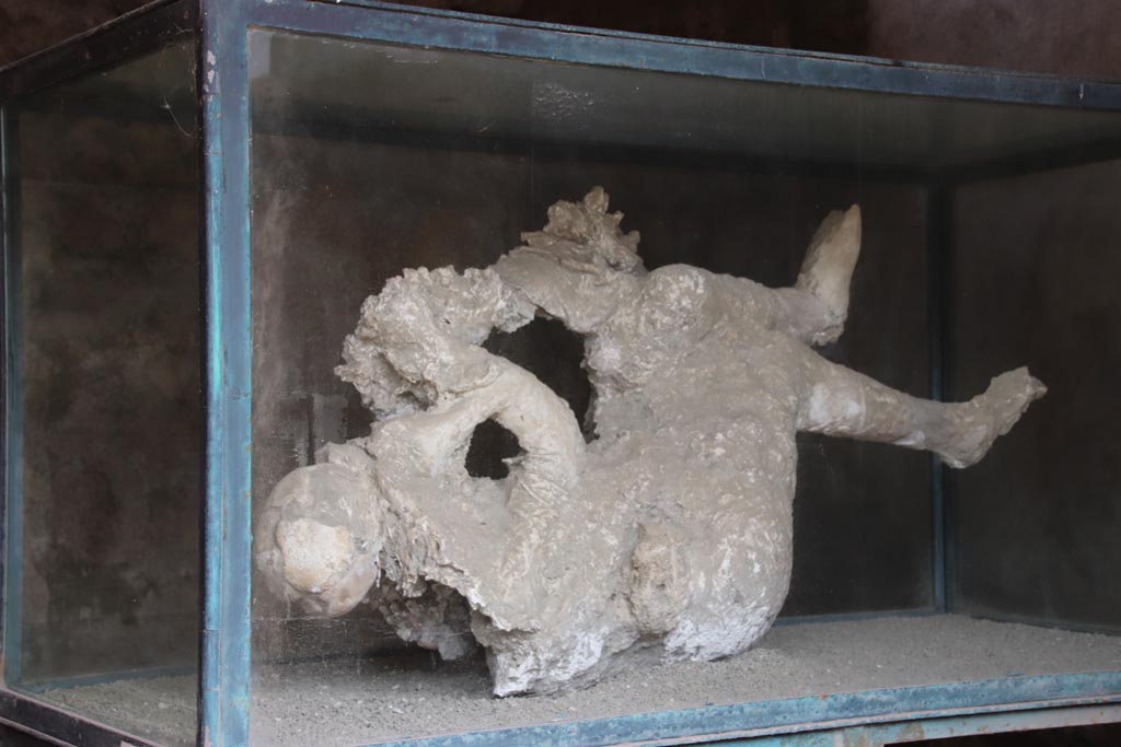 III.6.1 Pompeii. May 2024. Photo courtesy of Klaus Heese.
Victim 27. Plaster cast of female victim found in Vicolo di Venere, 8th to 12th September 1933 (two years before the excavation of the Caupona). 
See Giornale degli Scavi 1933, 8-12 settembre 1933.
See Osanna, N., Capurso, A., e Masseroli, S. M., 2021. I Calchi di Pompei da Giuseppe Fiorelli ad oggi: Studi e Ricerche del PAP 46, p. 381.
Luongo records the date as the date of the excavation of the caupona on March 11, 1935
See G. Luongo et al: Journal of Volcanology and Geothermal Research 126, (2003), p.185, with reference Arch. Pompei, GS 1935.

