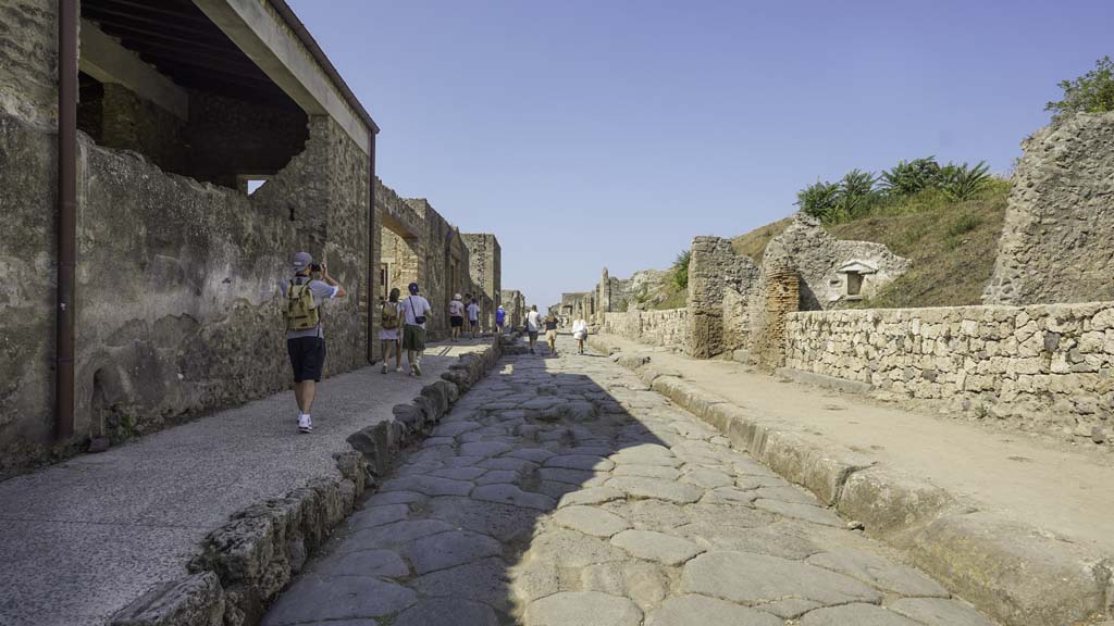 III.7.2 Pompeii, approximately in the centre, on right hand side. August 2021. 
Looking west along newly constructed wall along III.7 on north side of Via dell’Abbondanza. II.4.7 is on the left. Photo courtesy of Robert Hanson.
