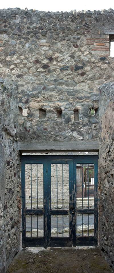 V.1.28 Pompeii. c.2008-10. Photo by Hans Thorwid.
Looking towards west side of entrance fauces/corridor “a”, with entrance doorway. 
