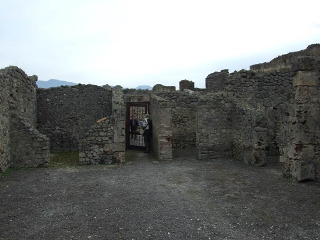 V.2.1 Pompeii. December 2007. Room 1, looking south across the atrium to the entrance.
On the south side of the atrium are the doorways to our rooms 2, on the left, and room 4, on right of entrance corridor.
The doorway to room 5 can be seen on the right.
(BdI, room letters on plan) - Doorway to room �u�, on left of entrance corridor, room �k� on right of entrance corridor, room �l� on right-hand side.
According to Mau, in the distribution of the rooms, this house did not follow the regular scheme but had obeyed the needs of the confined space.  
Around the atrium were three cubicula, (k, l and u), a storeroom or cella penaria (s), and the stairs to the upper floor (n); next to the tablinum and accessible from it were two spacious tricliniums (�p and r�), of which (�r�), which had a wide window in its north wall onto the garden could have been called the summer triclinium, and the smaller room with wide entrance (�o�) could have been used for family dinners.
See Mau, Bullettino dell�Instituto di Corrispondenza Archeologica (DAIR), 1885, p.158.

According to PPM,  
The atrium with a similar red zoccolo, divided into compartments, had the middle zone of the walls with raw (rough) plaster.  
The three cubicula (�k�, �l� and �u�) had tripartite walls in panels with vignettes (birds, deer, griffins, only in �l� a medallion with painted masks was preserved) in �k�, these were executed more crudely; in �u�, on the south wall in the lunette was preserved a painted basket from which figs had fallen. 
See Carratelli, G. P., 1990-2003. Pompei: Pitture e Mosaici: Vol. III. Roma: Istituto della enciclopedia italiana, (p.774). 