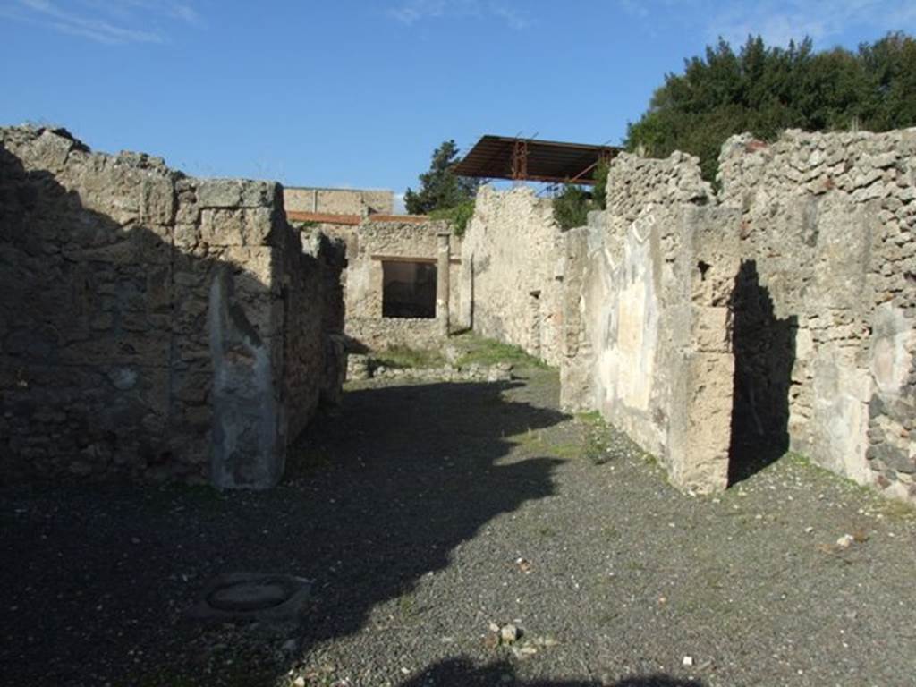 V.2.10 Pompeii. December 2007. Looking north towards room 3, tablinum.
According to NdS, opposite to the entrance corridor was the tablinum, with the doorframes covered in fluted white plaster.
On the east wall was the painting of Hippolytus and Phaedra, described in NdS and BdI.
See Notizie degli Scavi di Antichità, 1891, (p.268). 

According to BdI, the tablinum was painted in the “style of the candelabra” but was only preserved on the right (east) wall. In the middle of the wall between two thin green candelabra a white panel was left (1.50 high x 0.91 length). It showed Hippolytus and Phaedra, occupying nearly the entire width but was not higher than 0.80.
On the same wall, on the upper part to the left, (0.54 high x 0.42 length) but badly preserved was a painting with doors, in the usual manner. On the left, was a clothed woman playing the lyre which she held on her left side.
To the right of the centre, another fully-clothed woman (looking left) leaning against a column, raises her left hand, in which she holds an object in the guise of a roll(?) (un rotolo) and whose other extremity, seems to touch the chin. Further to the right up to the border, but further back, stands a building, open in front and back, in which you recognize a figure whose details are not distinguished: it seems, however, that she is naked and that she is putting a cloth on top of some furniture.
See Mitteilungen des Kaiserlich Deutschen Archaeologischen Instituts, Roemische Abtheilung Volume XXVI, 1890, p. 260-261).

