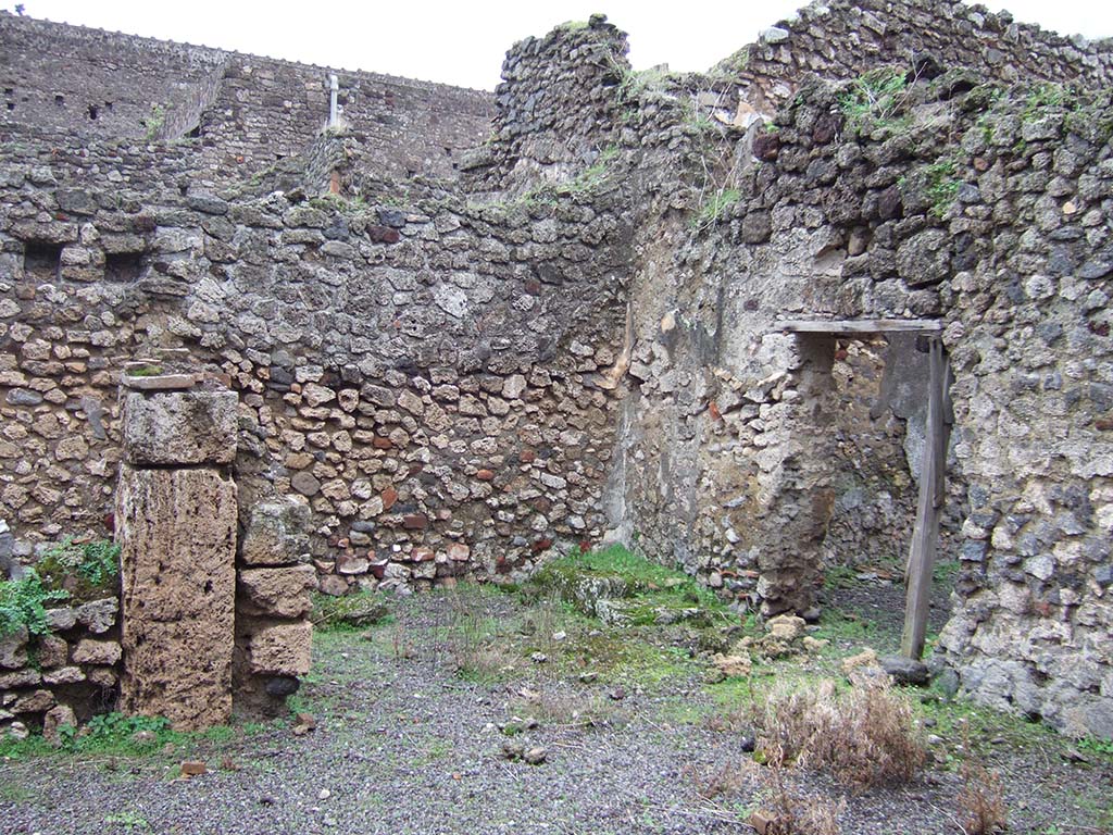 V.2.f, Pompeii. December 2005. Looking south-east across atrium. On the left would have been a cubiculum.
In the centre can be seen a room with remains of three masonry steps to an upper room above the cubiculum, and doorway to a small courtyard. 
According to NdS, on the black dado of the room with the stairs was a graffito � MID/
See Notizie degli Scavi di Antichit�, 1896, (p.436).
See Mau in Bullettino dell�Instituto di Corrispondenza Archeologica (DAIR), VIII, 1893, (p.7-9)
According to Jashemski, a terracotta dolium and several amphorae were found in the courtyard.
See Jashemski, W. F., 1993. The Gardens of Pompeii, Volume II: Appendices. New York: Caratzas, (p.112)
