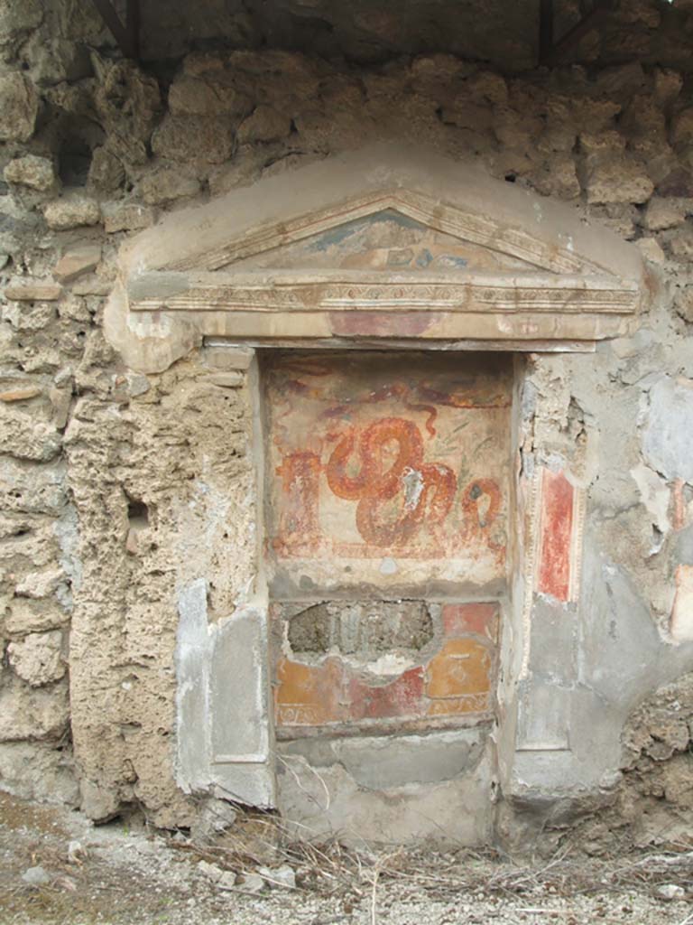 V.3.7 Pompeii. May 2005. West wall of garden area. Large aedicula lararium.
The pediment extends far beyond the supporting pilasters on each side.
The rear of the lararium has upper and lower zones which were divided by a partition.
See Boyce G. K., 1937. Corpus of the Lararia of Pompeii. Rome: MAAR 14. (112, p. 38, Pl 36, 2).