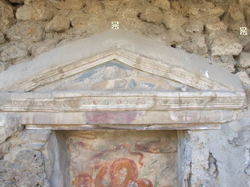 V.3.7 Pompeii. March 2009. West wall of garden area. Aedicula lararium pediment, with blue tympanum and decorative stucco. See Boyce G. K., 1937. Corpus of the Lararia of Pompeii. Rome: MAAR 14. (112, p. 38, Pl 36, 2).