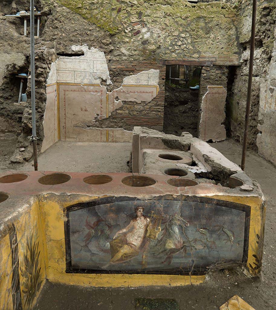 V.3 Pompeii, Thermopolium with painting of nereid. December 2020. Looking towards the south/rear of the thermopolium with wall decoration and door.

V.3 Pompei, Termopolio con dipinto di nereide e anfore. Dicembre 2020. Guardando verso la parte sud/posteriore del termopolio con decorazione murale e porta.

Photo by Luigi Spina courtesy of Parco Archeologico di Pompei.
