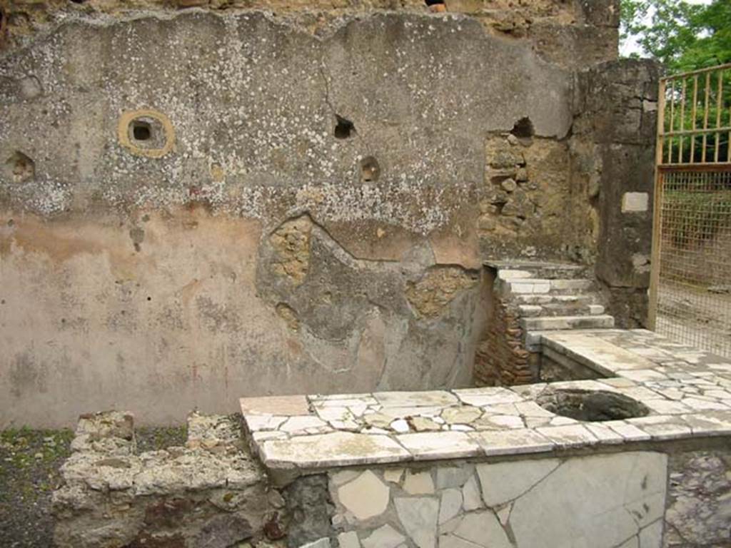 V.4.7 Pompeii. May 2003. Looking across counter and hearth towards east wall with display shelving. Photo courtesy of Nicolas Monteix.