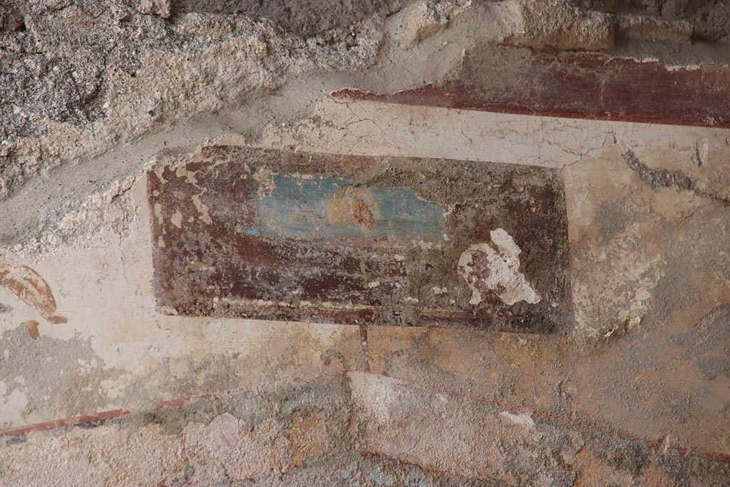 V.6.12 Pompeii. October 2024. 
Detail of painted panel from upper north wall of fauces/ entrance corridor above Priapus painting. Photo courtesy of Klaus Heese.
