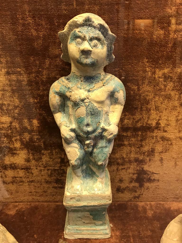 VI.1.2 Pompeii. April 2019. Statuette of Ptah-Pateco found in VI.1.2 on 6th October 1770.
Photo courtesy of Rick Bauer.
Now in Naples Archaeological Museum.  Inventory number 22607.
Sala (room) 88, glass cabinet V, shelf A (bottom).
See Di Gioia, E. (2006). La ceramica invetriata in area vesuviana. �L�Erma� di Bretschneider, (p.110-111).
