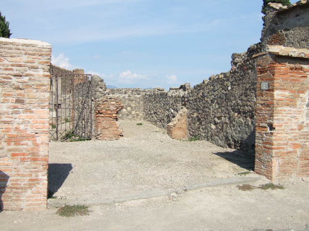 VI.1.4 Pompeii. September 2005. Entrance. According to Fiorelli, found on the wall at the side of the entrance was a graffito, now disappeared�
C. CVSPIVM  PANSAM
AED  MVLIONES  VNIVERSI
AGATHO  VAIO
He described the inn as having two small rooms, a triclinium, three dormitories, two areas for the carts without doors but protected by a roof, and to the right, the stable. See Pappalardo, U., 2001. La Descrizione di Pompei per Giuseppe Fiorelli (1875). Napoli: Massa Editore. (p.47)
According to Pagano and Prisciandaro, found here in August 1770 were two graffiti, the first painted in black letters read �
C(aium) Cuspium Pansam
aed(ilem) muliones universi
Agatho vaio    [CIL IV 97]
and on the same wall, but higher up painted in red was �
Postu[mium 3]
Iulius Polybius college
facit                   [CIL IV 98]
See Pagano, M. and Prisciandaro, R., 2006. Studio sulle provenienze degli oggetti rinvenuti negli scavi borbonici del regno di Napoli.  Naples : Nicola Longobardi. (p. 67)  PAH I, 1, 242.
According to Della Corte, found here were two skeletons of horses with the remains of their harnesses and iron wheels. In the courtyard, as well as two fountains or drinking troughs, were the remains of three carts.
See Della Corte, M., 1965.  Case ed Abitanti di Pompei. Napoli: Fausto Fiorentino. (p.31)
