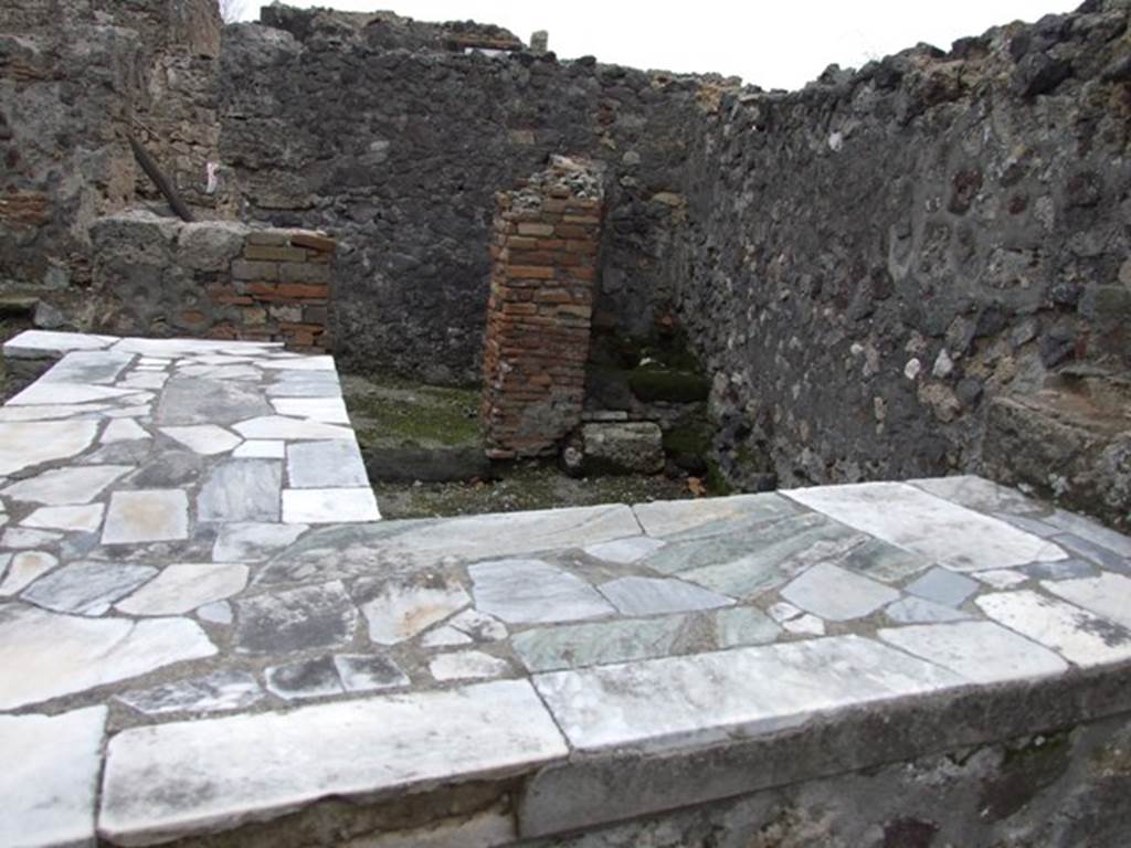 VI.1.18 Pompeii. December 2007. Two-sided marble counter with hearth and two tier shelving.