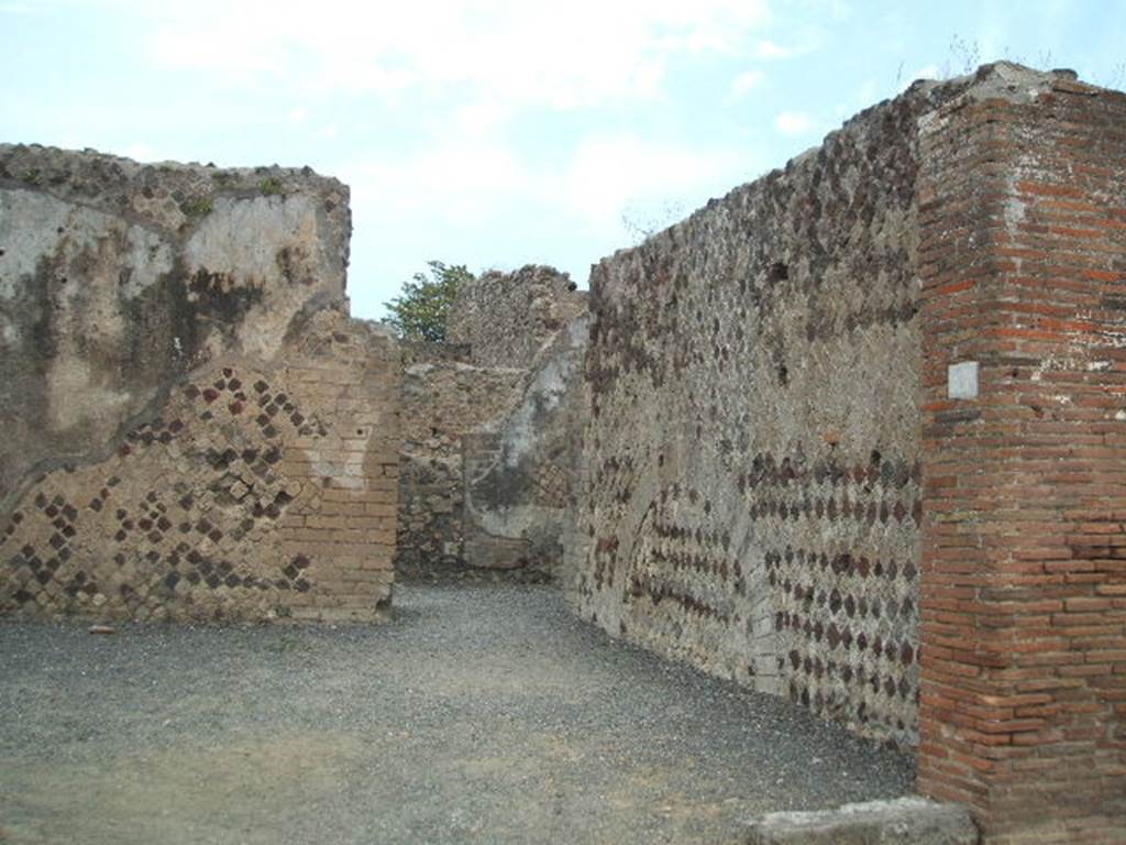VI.6.21 Pompeii. May 2005. Looking north along east wall of shop towards doorway in north-east corner into VI.6.17. According to Stefani, this was a large corner sales shop for the bakery at its rear. On the west wall was a lararium painting with serpent, on the facing wall was a supposed �cross� in stucco. See Stefani, G. (2005): Pompei. Un Panificio: in Cibi e Sapori a Pompei e dintorni, (p.139).