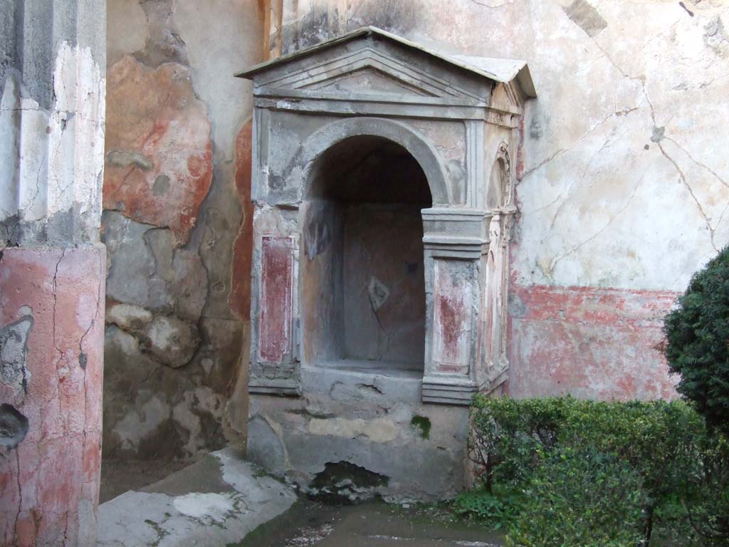 VI.8.3/5 Pompeii. December 2006. Aedicula lararium.
Boyce seemed doubtful that this was for the worship of the household gods and may have just been a decorative feature.
Many of the accounts of the discovery, state that a statuette of a faun was found within this niche, but other reports do not agree.
It is therefore impossible to know if this was the figure that was normally contained within the niche.
Anyway, it did seem likely that it did contain some such single statuette of ornamental character, rather than the images of the gods of the household.
See Boyce G. K., 1937. Corpus of the Lararia of Pompeii. Rome: MAAR 14. (p.48, no.168 and Pl.30,3), and other references.

According to Pagano and Prisciandaro, reported on 28th January 1825, found in the tablinum was a marble statuette of a faun, broken in three pieces.
Now in Naples Archaeological Museum. Inventory number 6347.
See Pagano, M. and Prisciandaro, R., 2006. Studio sulle provenienze degli oggetti rinvenuti negli scavi borbonici del regno di Napoli. Naples: Nicola Longobardi, p. 132.
PAH II, 126, reporting the discovery on 12th February 1825 called it a lararium for the household gods, and did not mention a statue of a faun.

According to Jashemski, PAH II,125 reported that the statuette of a marble faun (MN 6347) carrying a goatskin full of fruit around his neck was found to the left of the tablinum.
Minervini, thirty-three years later reported that the statue was found in the aedicula, and this account has been repeated down the years.
The shell of a tortoise which had been kept in the garden was also found.
See Jashemski, W. F., 1993. The Gardens of Pompeii, Volume II: Appendices. New York: Caratzas. (p.133, with photos 142, and 143 (marble faun).
