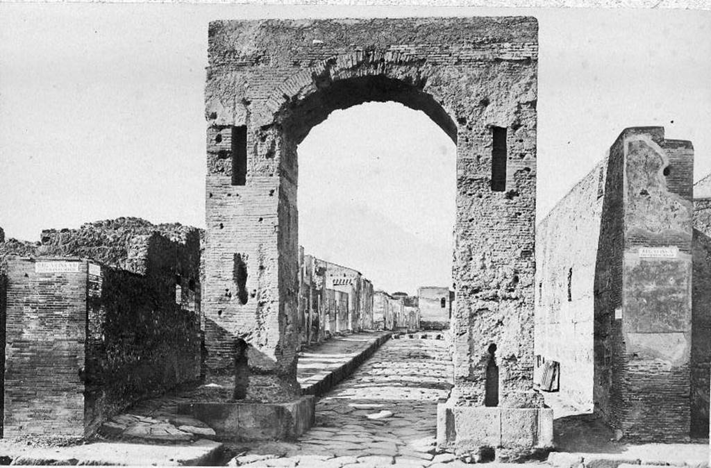 VI.8.11 Pompeii, front and side wall, on left of picture.
Looking north through Arch of Caligula along Via di Mercurio. About 1870. Photo courtesy of Rick Bauer.
According to Pagano and Prisciandaro, graffiti were found on these walls in 1824.
Found on the wall to the left of the arch was �

Hypsaeum
quinq(uennalem) d(ignum) r(ei) p(ublicae)    [CIL IV 270]

C(aium) Iulium Polybium
d(uumvirum) i(ure) d(icundo) o(ro) v(os) f(aciatis)    [CIL IV 271]

M(arcum) Lucretium [F]ro[ntonem]    [CIL IV 272]

See Pagano, M. and Prisciandaro, R., 2006. Studio sulle provenienze degli oggetti rinvenuti negli scavi borbonici del regno di Napoli. Naples: Nicola Longobardi, (p.128)
See Fiorelli G., 1862. Pompeianarum antiquitatum historia, Vol. 2: 1819 � 1860. Naples, p. 91.
See Fiorelli G., 1864. Pompeianarum antiquitatum historia, Vol. 3. Naples, p. 47.
