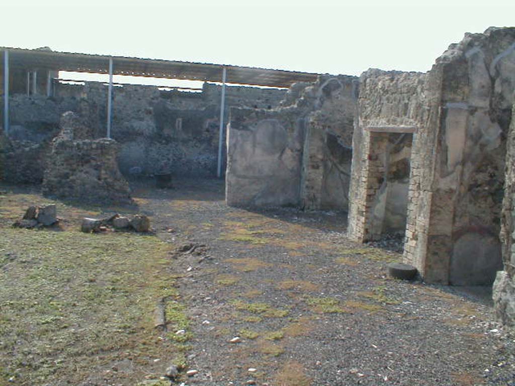 VI.9.5 Pompeii. September 2004.
Looking south across west portico of Corinthian atrium 16, towards the remains of the area of a pseudo-peristyle 19, ahead.
On the right is the east end of the room 14 the entrance corridor, followed by a doorway to a cubiculum, room 17 and oecus, room 18.