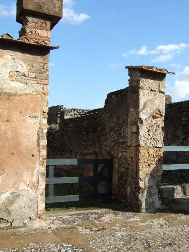 VI.10.4 Pompeii. December 2005. Entrance doorway.
According to Leach, a respectable tavern couple, Caprasia and Nymphius, supported the campaign of their down-the-street neighbours the Vettii. She said that given that Caprasia�s name showed a family affiliation with Vettius�s adoptive son Caprasius, the connection drew her attention to the social dynamics of the neighbourhood. See Leach, E.W: The Social Life of Painting in Ancient Rome and on the Bay of Naples.
According to Della Corte, Caprasia lived on this insula, together with Nymphius, perhaps her husband.  They ran the caupona at number 3, from the front of the dwelling at number 4. A written recommendation was found on the pilaster between 6 and 7 -  Caprasia cum Nymphio rog(at) una et vicini   [CIL IV 171] See Della Corte, M., 1965.  Case ed Abitanti di Pompei. Napoli: Fausto Fiorentino. (p.55)

According to Epigraphik-Datenbank Clauss/Slaby (See www.manfredclauss.de), this read as �

A(ulum) Vettium Firmum 
aed(ilem) o(ro) v(os) f(aciatis) dign(um) est 
una et vicini o(ro) v(os) f(aciatis)             [CIL IV 171]

According to Coarelli and Pesando, CIL IV 171 reads as �
A VETTIVM FIRMVM 
AED O V F DIGN EST 
CAPRASIA CVM NYMPHIO ROG
VNA ET VICINI O V F

See Coarelli, F. and Pesando, F. (a cura di), 2006. Rileggere Pompei, Volume 1: L�insula 10 della Regio VI. Roma: L�Erma di Bretschneider. (p. 106-7).
