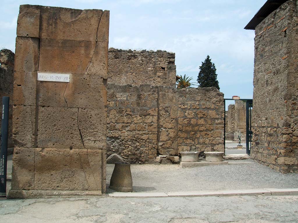 VI.12.1 Pompeii. May 2005. Shop entrance doorway, looking north.  
According to Fiorelli, found painted on the first corner pilaster, on the left, were the remains of an �Eituns�, or Oscan inscription.
Only a few letters were still visible.
See Pappalardo, U., 2001. La Descrizione di Pompei per Giuseppe Fiorelli (1875). Napoli: Massa Editore. (p.71)
See Antonini, R., in Quaderni Di Studi Pompeiana, 1/2007, Assoc. Int. Amici di Pompei, p. 57-73.

