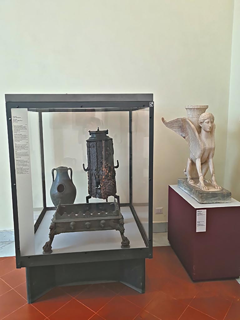 VI.12.2 Pompeii. September 2024. 
Display case with items – Portable bronze brazier, Stove and bronze chafing dish.
Now in Naples Archaeological Museum. Photo courtesy of Giuseppe Ciaramella.
