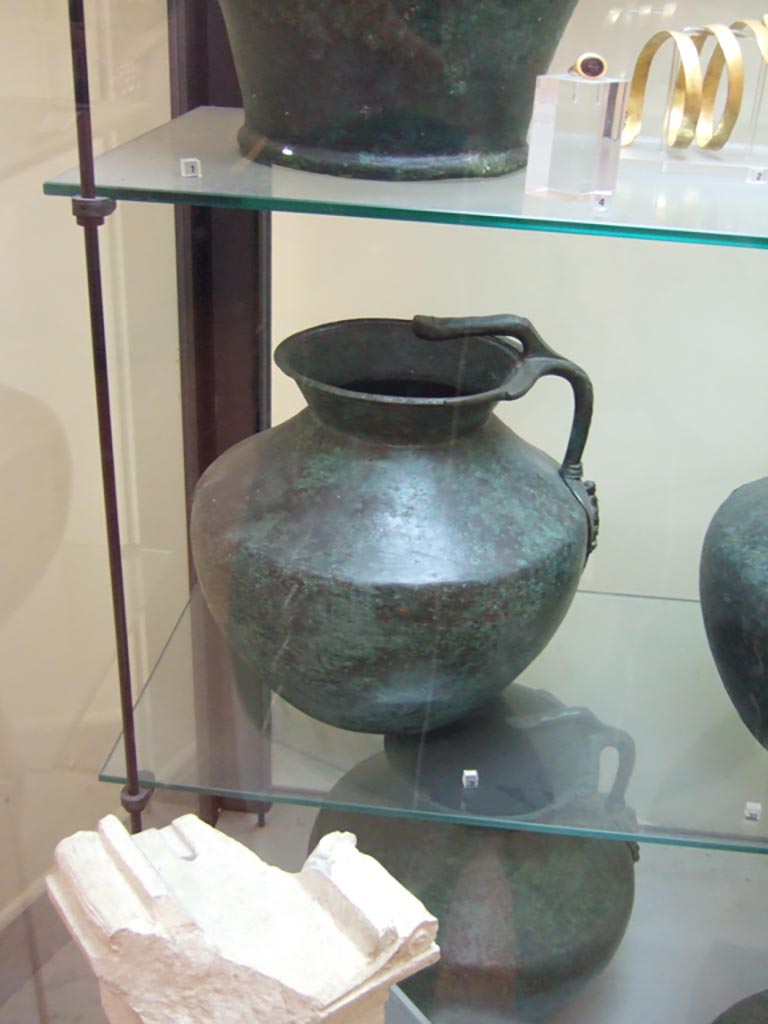 VI.12.2 Pompeii. One handled bronze jug, with small limestone altar, below. 
Now in Naples Archaeological Museum. Inventory number 69425.

The small altar (second half of the 2nd century BC), found 1831, now in Naples Archaeological Museum. Inv. 2550 (Vetter 21), with Oscan inscription, written from right to left, reading –
“To flora”
(Piccola ara (seconda metà del II secolo a.C.), trovato 1831, inv. 2550 (Vetter 21), alfabeto osco, scrittura da destra verso sinistra –
“A Flora”)
According to the information card in Naples Museum –
“Flora is one of the minor deities connected to the regenerative cycles of nature. Her cult was diffused through the Italic world, and is attested in Rome as well”.
(“Flora è una delle divinità minori legate ai cicli rigenerativi della natura, il cui culto era diffuso nel mondo italico e si ritrova anche a Roma.”)

