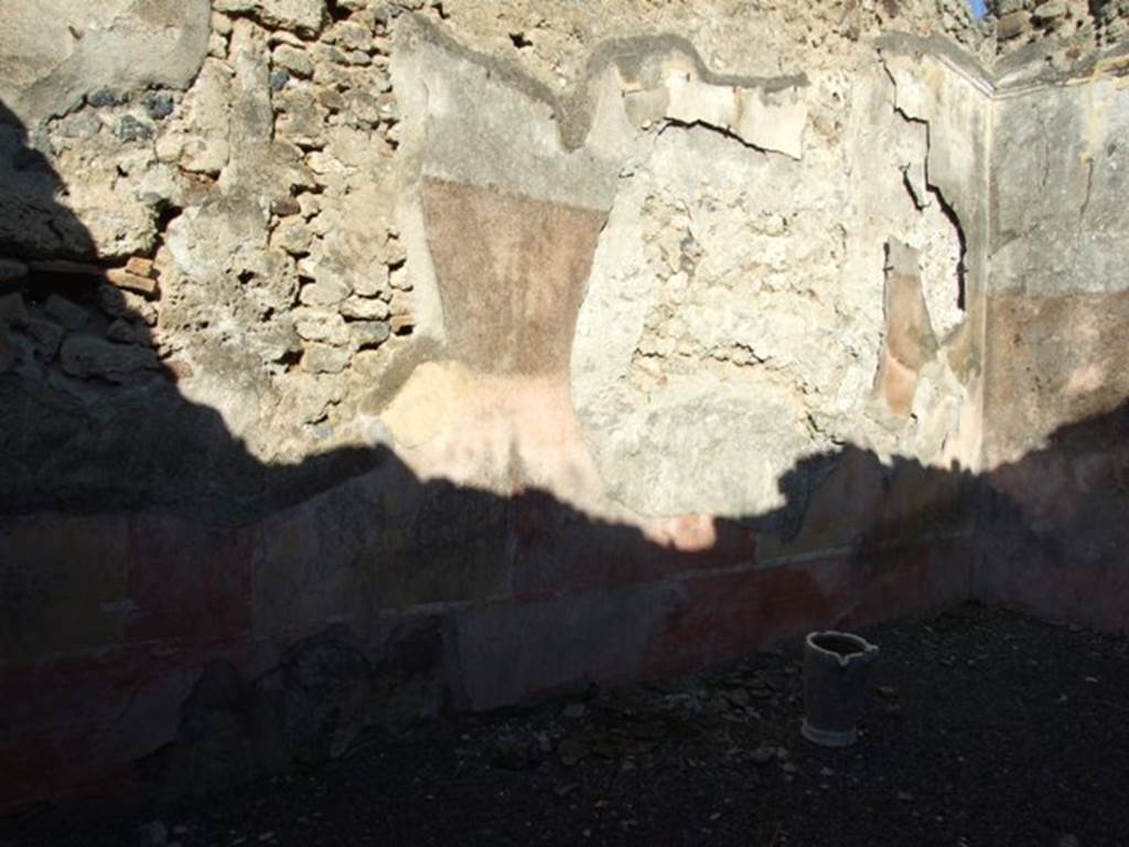 VI.14.22 Pompeii. December 2007. Room 15, north wall of triclinium.
According to BdI, on this wall (the left wall) the following paintings were seen upon excavation, beginning from the left (west end): Flying cupid.
Medallion, completely vanished.
In the middle of the wall, but nearly vanished (1.13 high x 1.10 wide) Narcissus, and on the extreme left, a female figure, probably sitting on a rock.
Medallion, vanished.
(0.38 x 0.06) mask just recognisable.
Flying cupid, with large green wings carrying a plate-shaped pot.
On the upper part of the wall was the usual fantastique architectural decoration with the following figures – Left wall, from left to right: Flying female figure, Nereide on sea-horse, Vittoria with shield and lance. See BdI, 1876, (p.24-28)