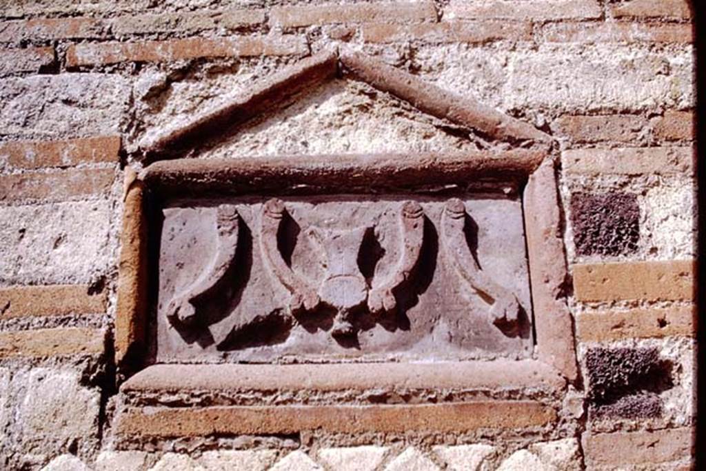 VI.14.28 Pompeii. 1968. Plaque on outside wall showing a “fritillus” between four phalluses. 
Photo by Stanley A. Jashemski.
Source: The Wilhelmina and Stanley A. Jashemski archive in the University of Maryland Library, Special Collections (See collection page) and made available under the Creative Commons Attribution-Non Commercial License v.4. See Licence and use details.
J68f0676
