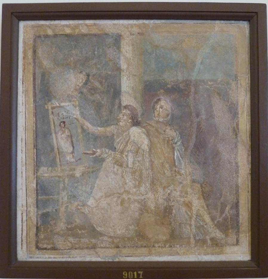 VI.14.42 Pompeii.  Found in Cubiculum (3), the room on the south (or right) of the entrance corridor.   Wall painting of woman painting.  
She holds a palette in her left hand and is painting a picture on a table or easel with the right.  A woman in yellow, with a white mantel over her shoulder, sits next to her. The woman admires the painting which is of a woman in a yellow robe. Now in Naples Archaeological Museum.  Inventory number 9017. See Helbig, W., 1868. Wandgem�lde der vom Vesuv versch�tteten St�dte Campaniens. Leipzig: Breitkopf und H�rtel. (1444). See Richardson, L., 2000. A Catalog of Identifiable Figure Painters of Ancient Pompeii, Herculaneum. Baltimore: John Hopkins. 
(p.120, he described it as a Genre scene with woman painting a picture, found in cubiculum 3, south of fauces).
