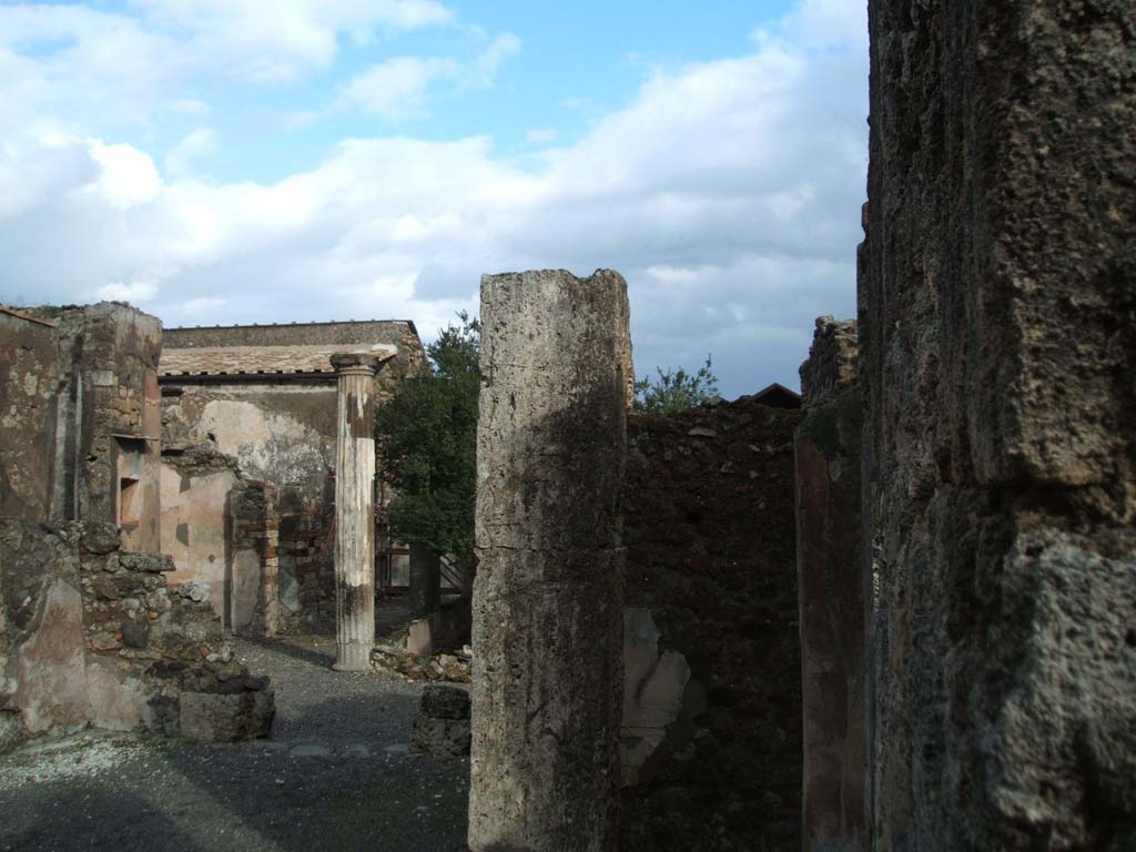 VI.14.43 Pompeii. December 2004. Looking east across atrium towards doorway to room 8, on right of centre.
Room 7, (on left) looking through tablinum to west portico, and north side of rear of house.
According to Jashemski, the peristyle garden, excavated in 1839, entered by a corridor from the atrium, had walls decorated in the first style.
The portico which enclosed the garden on the north and part of the west sides was supported by four fluted columns joined by a low wall.
See Jashemski, W. F., 1993. The Gardens of Pompeii, Volume II: Appendices. New York: Caratzas. (p.151).