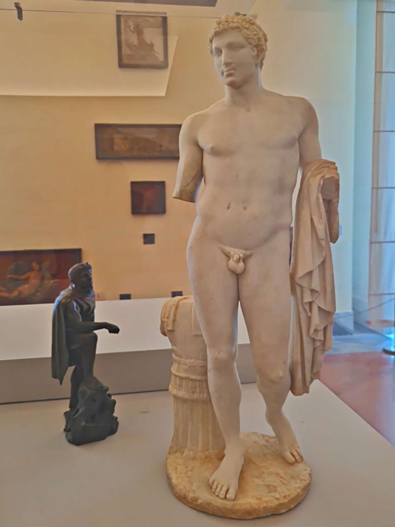 ???VI.14.43 Pompeii. October 2023.
According to the MANN description card above, this is the marble statue of Hellenistic ruler (?), inv. 6389.
According to Jashemski, the photo of this statuette in her book is described as being “of Mars” (0.68m high without base) and numbered as
inv. no. 126249, as above statue. Photo courtesy of Giuseppe Ciaramella.
On display in “L’altra MANN” exhibition, October 2023, at Naples Archaeological Museum.
See Jashemski, W. F., 1993. The Gardens of Pompeii, Volume II: Appendices. New York: Caratzas. (p.152, inc. photo of statue of Mars, fig.164).