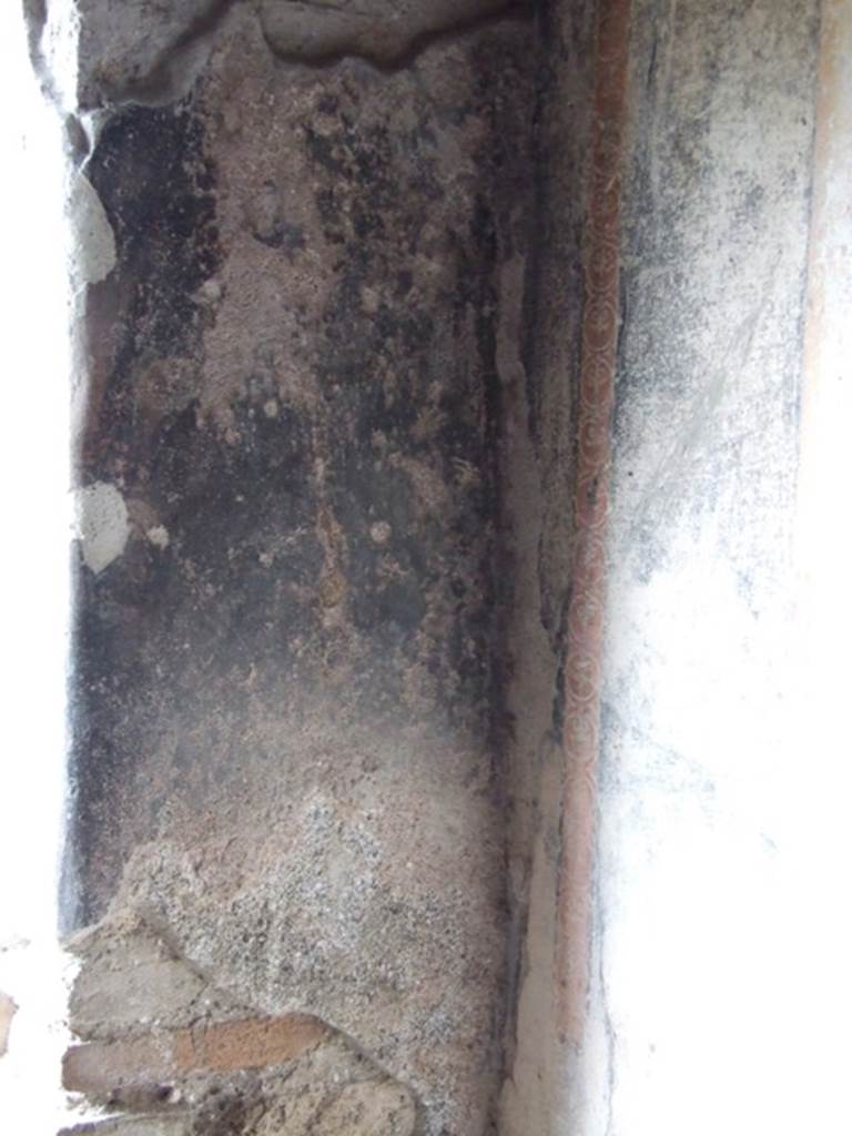 VI.15.6 Pompeii. March 2009. Room 15, remains of wall decoration in north-west corner of triclinium, to the north of door.