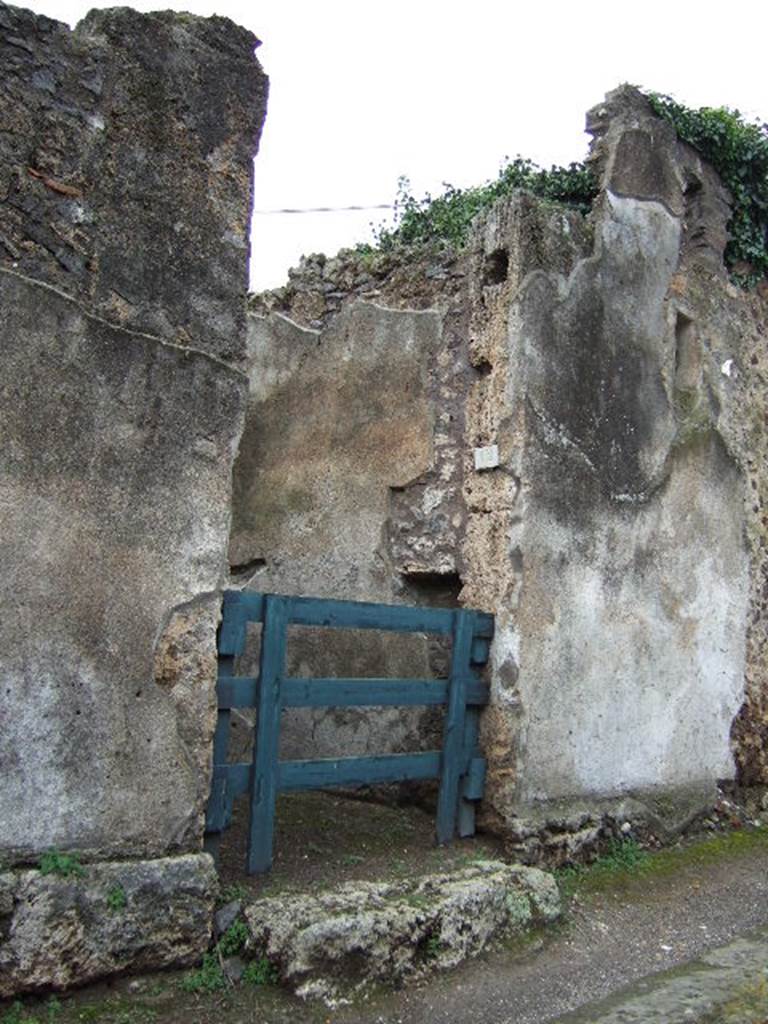 VI.15.12 Pompeii. December 2005. Entrance doorway, leading to a modest house, according to Sogliano in Notizie degli Scavi. According to Della Corte, this house was given its name, by the finding of an amphora with the words �
 (Vinum) Pompei(anum)
T. Vedio Vest(ali), ab Castricio    [CIL IV 5559 with note 2  on page 63]
See Della Corte, M., 1965.  Case ed Abitanti di Pompei. Napoli: Fausto Fiorentino. (p.63)
