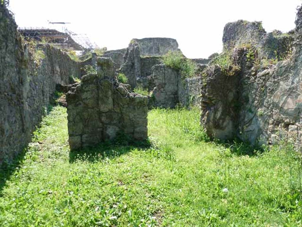 VI.16.11 Pompeii. May 2010. Looking west across shop to corridor to rear, on left, and rear room in north-west corner, on right. Originally, on the west wall between the corridor and the rear room was a lararium. According to Boyce, there was a ruined niche in the west wall, coated with white stucco bordered with red stripes. Red and green garlands were painted on the back wall of it. See Notizie degli Scavi di Antichit�, 1908, p. 58. See Boyce G. K., 1937. Corpus of the Lararia of Pompeii. Rome: MAAR 14.  (p. 58, no.222).
