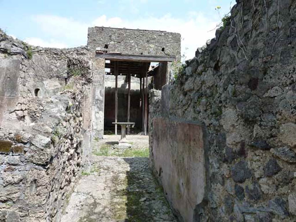 VI.16.28 Pompeii. May 2010. Looking east along fauces A, to atrium C. The floor was made of cocciopesto, in which was buried some pieces of marble without a design. The south wall preserved a high dado on a blackish background, finishing above with a wide red frieze.
Under the frieze was a simple coating of rough white plaster.  Found on the south wall, shown here on the right,  was a graffito MVSQ?N . Above on a coarse white plaster, in rather large letters was COPONII. From this graffito of Coponii, the house gained one of its names. See Notizie degli Scavi di Antichit�, 1908, p. 271.
