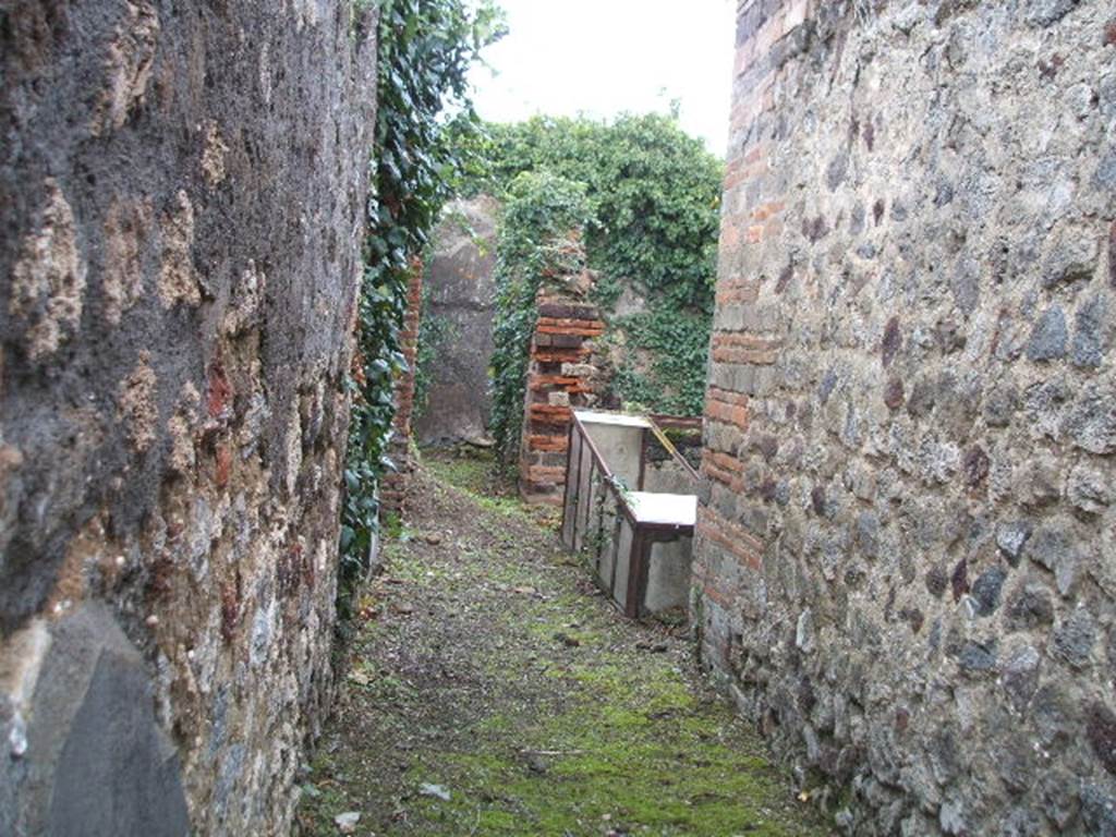 VI.16.35 Pompeii. December 2007.  Looking east from entrance doorway across fauces A towards atrium B, towards small corridor G leading to rear rooms. The rise in the floor of the corridor in the centre of the photo, would be the remains of the steps. On the right, on the east side of the atrium, the small tablinum can be seen.

According to NdS, the small atrium B was bare-walled and the floor was Opus signinum.
At the time of excavation it was noted for its impluvium �a�. This had a very high edge, faced with cocciopesto which had some pieces of encrusted marble in the upper horizontal surface. Running around the inside part was a decoration of  lines of yellow stucco in relief, and in each of the four corners, small palms, also in relief. The background consisted of a large disc of white marble and around it pieces of marble of various colours. The walls of the atrium were decorated with simple white plaster, the floor was of cocciopesto and formed a continuation with the floor of the fauces. At the extreme right of the northern wall of the atrium were three steps in masonry, plaster coated. Following these, a staircase also in masonry recessed between rooms E and H, leading to the upper floor.

On the east side of atrium B opened the full-width tablinum C. It had bare walls and its floor was Opus signinum, similar to the atrium and fauces. The left jamb would have been of wood, and it corresponded on the right with a brick pilaster. In the east wall of the tablinum would have been a wide window which would have had a wooden window-sill. This window gave light into room F, which was all faced with cocciopesto.

On the west side of the atrium was a doorway into room D, this doorway had wooden jambs and a threshold of masonry forming a step. The room did not provide anything notable, it had cocciopesto flooring and walls with a white background divided by red lines into large panels. In the west wall was a window overlooking Vicolo dei Vettii. 

On the north side of the atrium was a doorway which was to the left of the aforementioned stairs, this led into room E. The doorway had wooden jambs and it seemed also, a threshold of wood. The rectangular room had a floor of cocciopesto and walls with a high plinth of brick plaster. In the south wall a small window protruded into the atrium.

Room G was a rather narrow corridor, whose entrance from the atrium had a wooden threshold. In its eastern half it was only separated from room F by a low wall. In the corner of this low wall and the east wall, the mouth of a tank made of terracotta, covered in robust masonry was found, �b�.

Room H opened from the north side of corridor G, its doorway had a lava threshold and originally would have had wooden door-jambs. This room did not offer any other decoration other than the usual brick plaster plinth on the walls, and floor of cocciopesto. A pile of lime was in the north-west corner.  To the right of the doorway in the south wall, was a window into corridor G, and in the west wall was a room under the stairs. This room was transformed into an apotheca, as proved by the holes for the shelving supports. See Notizie degli Scavi, 1908, (p.359-363)


