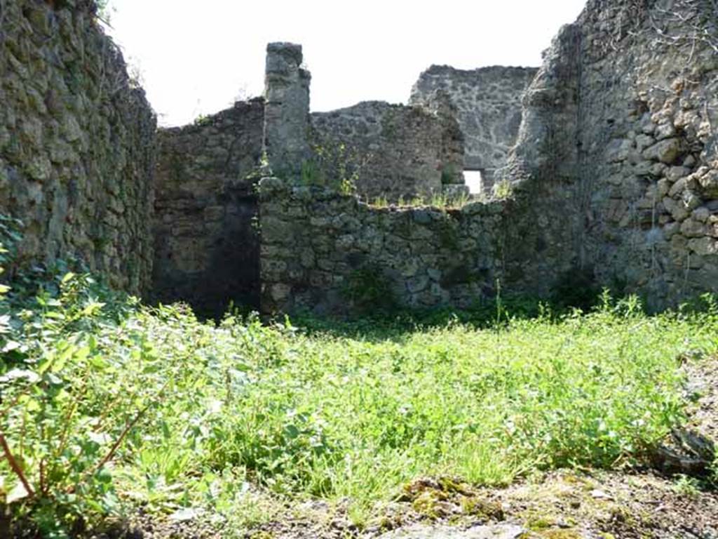 IV.16.35 Pompeii. May 2010. Rear room, kitchen I, on the east side. Looking west from VI.16.11. The doorway into the kitchen from the corridor is in the rear (west) wall on the left of the picture. Sogliano�s description was written as arriving into the kitchen from this corridor. Our picture was taken from the other side of the room.
According to NdS, corridor G turned at right-angle to the north, and then again at right-angle to the east, where it immediately opened into the kitchen, room I.
The hearth �c� leaned to the left end of the east wall, (right front of this photo).
It had roof tiles on its edge and an arched empty space below.
Perpendicular to the south wall were two parallel walls, which formed two small rooms, (area on the left of this photo).
Room �d� was the latrine.
Room �e� was a repository.
See Notizie degli Scavi di Antichit�, 1908, (p.359-363)