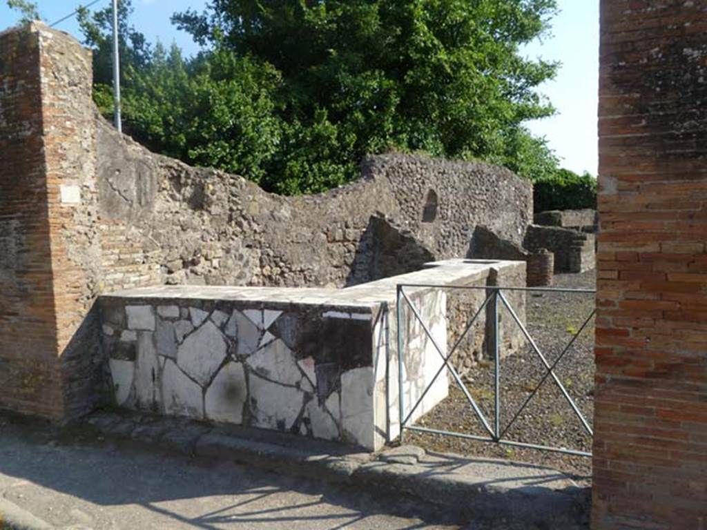 VI.17.4 Pompeii. May 2011. Looking west towards two-sided marble counter with display shelves.