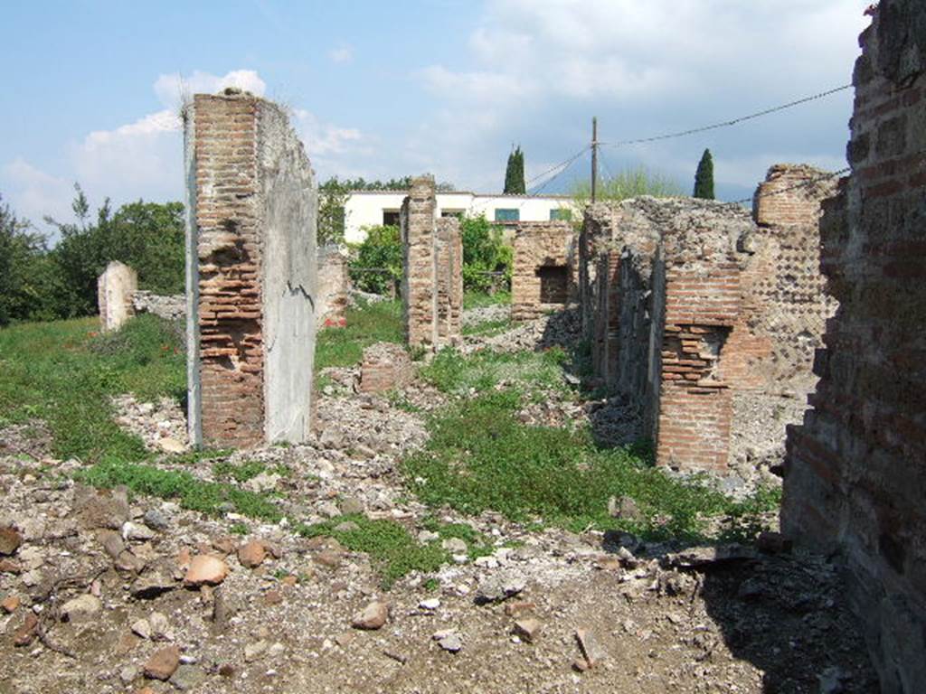 VI.17.36 Pompeii. May 2006. Looking north along remains of east side of rear peristyle area, taken from VI.17.41. According to Jashemski, steps at each entrance (VI.17.32 and 36) led to an atrium: immediately at the rear of these there was a large peristyle garden. This was enclosed by a portico on 4 sides. In the middle of the garden was a pool with a fountain, with little steps leading into the pool, but this was no longer in existence when Breton wrote. See Jashemski, W. F., 1993. The Gardens of Pompeii, Volume II: Appendices. New York: Caratzas. (p.166 with plan). See Breton, Ernest. 1870. Pompeia, Guide de visite a Pompei, 3rd ed. Paris, Guerin. (p.266)