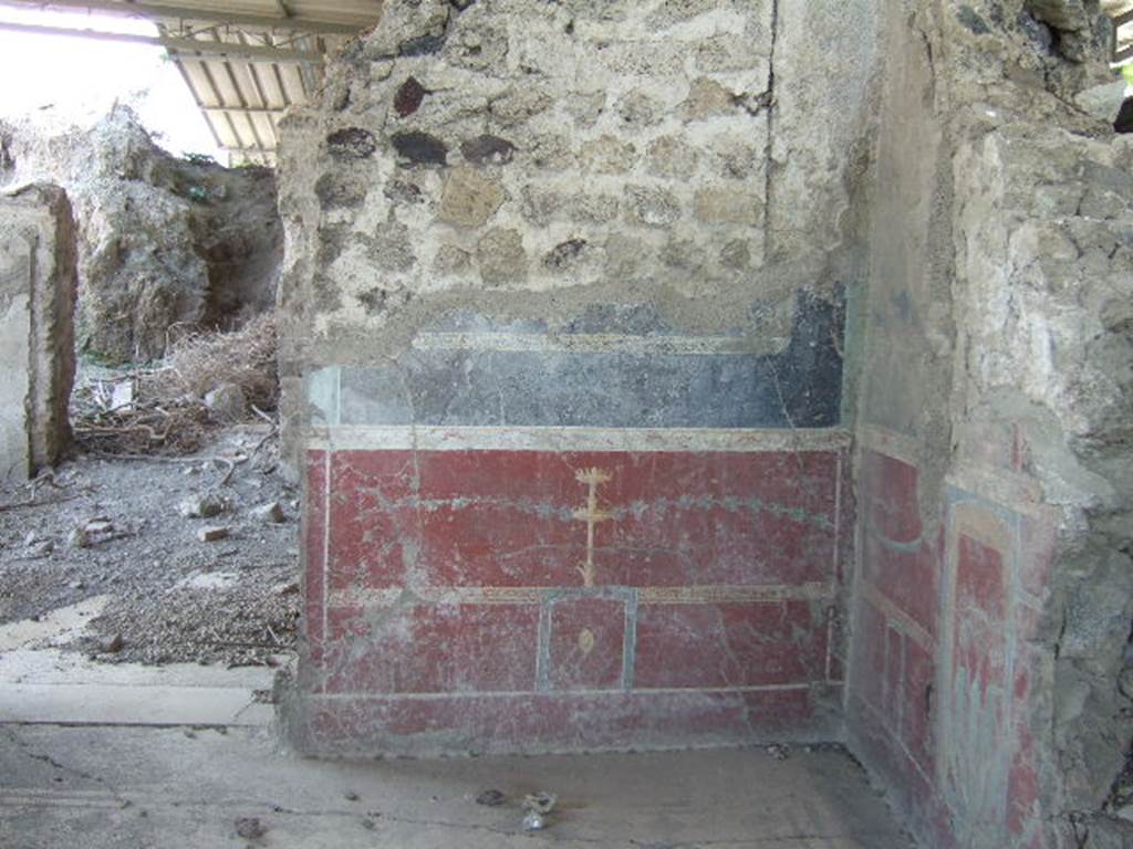 VI.17.36.Pompeii. May 2006. Taken from VI.17.41. East wall and doorway, looking towards south-east corner in eastern cubiculum (room “a”) of VI.17.36, on south side of peristyle.
According to PPP, the east wall had a red panelled zoccolo, in the central panel was an painted plate/medallion with a painted candelabra above it. The middle zone of the wall would have been black.