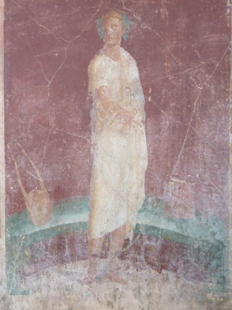 VI.17.41 Pompeii. October 2010. east wall of exedra 18 on north side of cubiculum 17. 
Detail of painting of robed figure with instruments. Photo courtesy of Gaby Gro�e.


