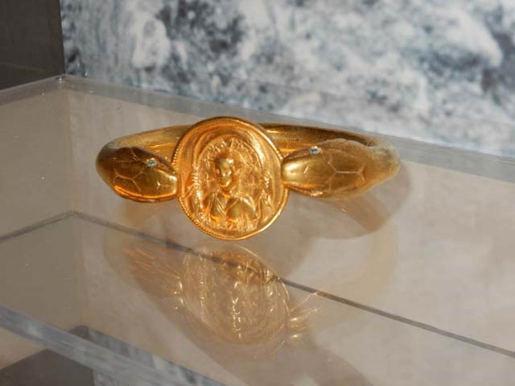 VI.17.42, Pompeii, May 2018. Golden bracelet with serpent heads grasping a disc with the bust of the goddess Luna.
Parco Archeologico di Pompei, inventory number 14268. Photo courtesy of Buzz Ferebee.