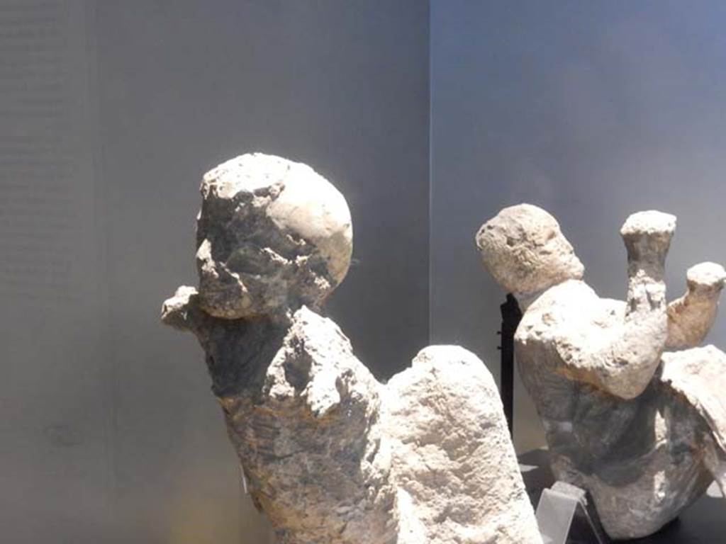 VI.17.42, Pompeii, May 2018.
Plaster cast of a child, on left, and man, on right, found in the corridor leading to the garden area.
Photo courtesy of Buzz Ferebee.