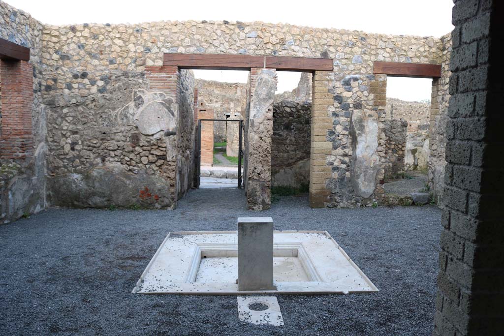 VII.1.25, Pompeii. December 2018. 
Looking east across impluvium in atrium 24 to fauces 23 and entrance VII.1.25. Photo courtesy of Aude Durand.
