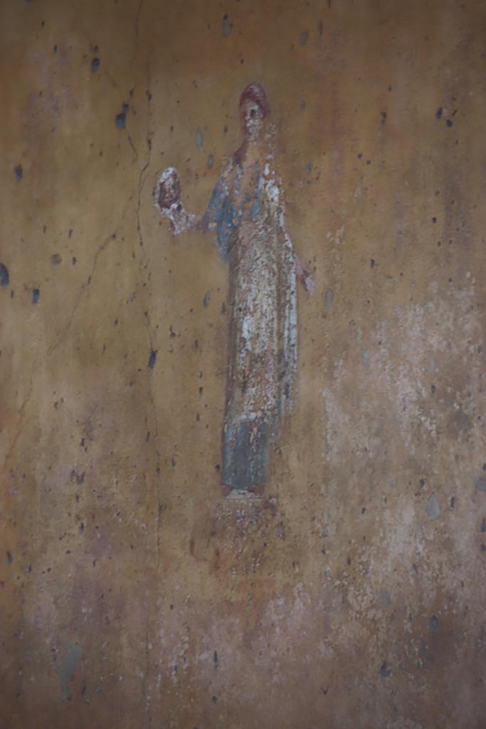 VII.1.47 Pompeii. October 2023. 
Exedra 10, Muse Thalia from north (left) yellow panel on the east wall. Photo courtesy of Klaus Heese.
