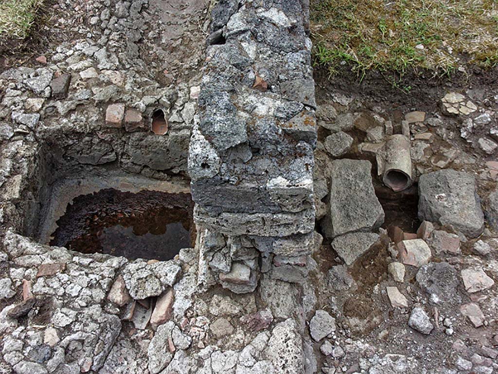 Fig. 30 – Pompéi, boulangerie VII 2, 3.6 – Dernier état du système de collecte et d’évacuation de l’eau.
Vue du sud.
La rigole longeant le péristyle aboutit dans un bassin de décantation relié à une canalisation maçonnée qui file vers l’extérieur, à l’est.
Cliché : A. Delvigne-Ryrko – EFR.
