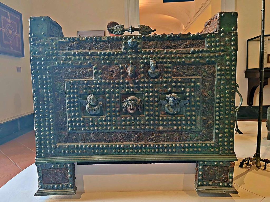 VII.2.18 Pompeii. October 2023. Detail of front of “arca”, storage/money-chest, which would appear to be the same as the Niccolini drawing below. 
The figure to the left of the boar’s head is now missing. Photo courtesy of Giuseppe Ciaramella.
On display in “L’altro MANN” exhibition, October 2023. 
