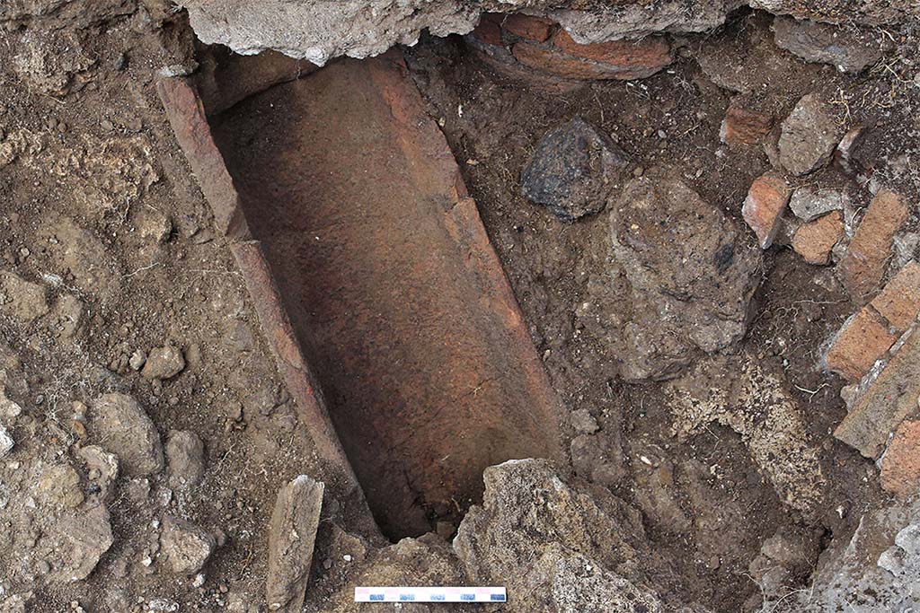 Fig. 37 � Pomp�i, boulangerie VII 2, 22 � Rigole de vidange du bassin construite avec des imbrices.
On distingue sur la droite la colonne constituant l�angle du bassin et son effondrement. En haut, la ligne de mortier visible constitue la base de la reconstruction moderne du bassin (vue de l�est).
Clich� : C. Salviani � EFR.
