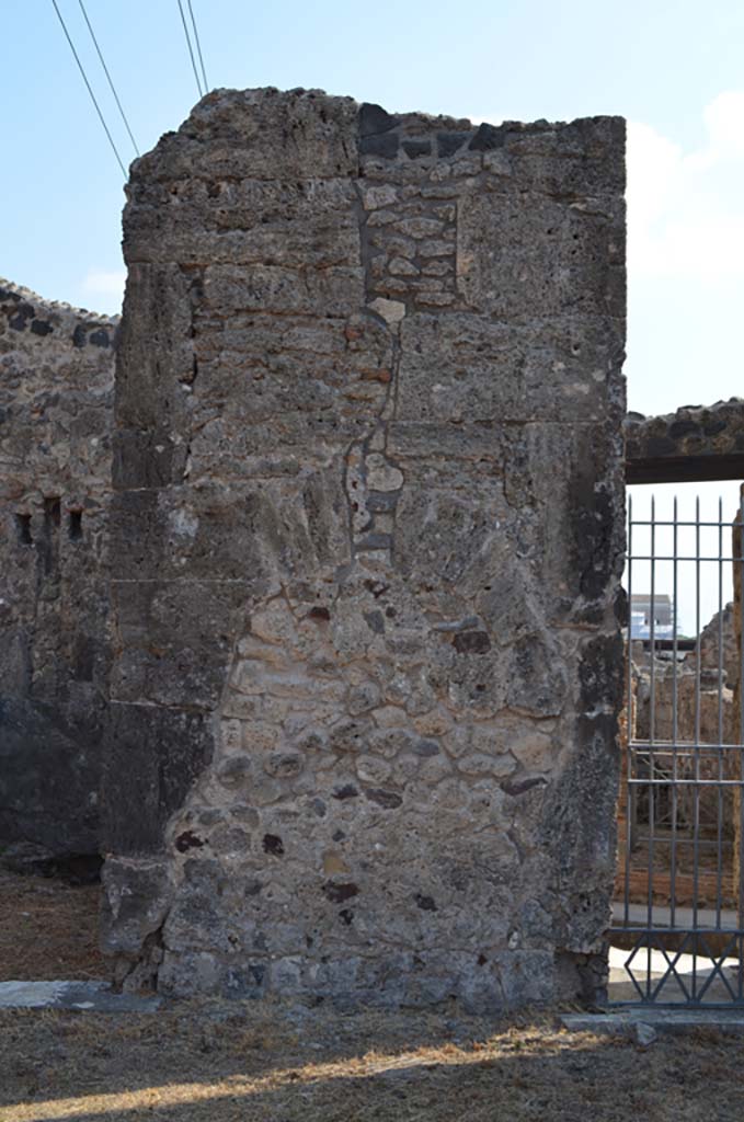 VII.4.31/51 Pompeii. September 2019. 
Pilaster on east side of atrium, with filled in niche, between doorways to room 9, and entrance doorway into room 10, leading to VII.4.33, on right.
Foto Annette Haug, ERC Grant 681269 DÉCOR.
(Note: our numbers are different to other plans, 
- PPM would indicate a pilaster between rooms 10 and 11,
- Descoeudres used the same numbering).

According to Descoeudres – in the atrium “above this high marble veneered dado, the walls were painted.  
None of the paintings are extant, but the 19th century excavation notes mention one of them which at the time was still to be seen.  
It is described as “a bizarre frieze showing the carriage of Bacchus (or Dionysus) with 2 panthers yoked to it, and on either side garlands of grapes against which 2 ladders rest with 2 cupids climbing up”.
(In the archive of NAP there is a water colour tracing which obviously depicts half of this frieze. (Fig 40, page 69). One can see that the carriage contained a mask of Dionysus and not Dionysus himself.  Since it is a tracing it is at actual size and it is clear that the full frieze, which must have been the border of a large panel must have been at least 1.5m wide.  There are not many long stretches of wall in the atrium which was surrounded by many entrances and doors, and the only wall in the atrium at the time of excavation that was long enough to accommodate such a large panel was that between rooms 10 and 11.  

Closer examination of this wall also reveals a niche, which at some stage was badly damaged (by earthquake?).  
The vertical crack which can still be seen is typical of earthquake damage). The wall was later repaired and the niche filled in.  
This was probably the site of the original Lararium – this is usually located in the atrium, but in this house it is located in the west ala (7). (Note: our room 6).  
It was probably moved there after the earthquake, probably after 62AD. 
The wall where it had originally stood was then repaired and covered with marble veneer.  
If this interpretation is correct, then the application of marble veneer to the atrium walls must have been done after 62 AD.”
See Descoeudres J-P., Ed., 1994. Pompeii Revisited: The life and death of a Roman town. Sydney: Meditarch, (p.70-71).

