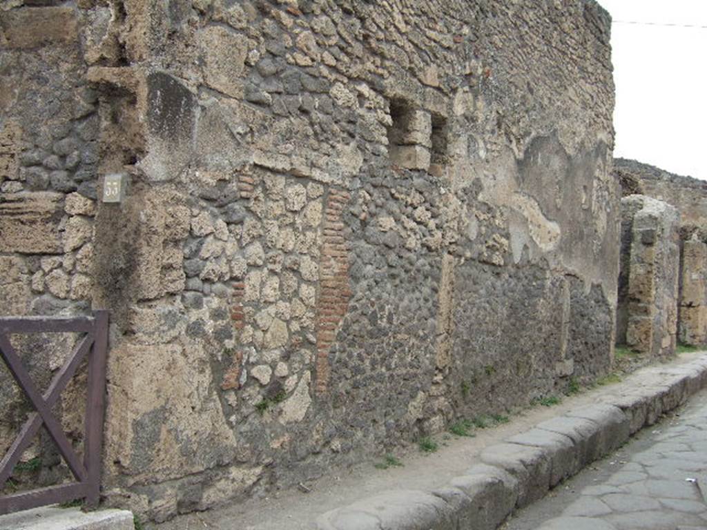 Street wall between VII.4.33 on left and VII.4.34 right. May 2006. Looking north-east.