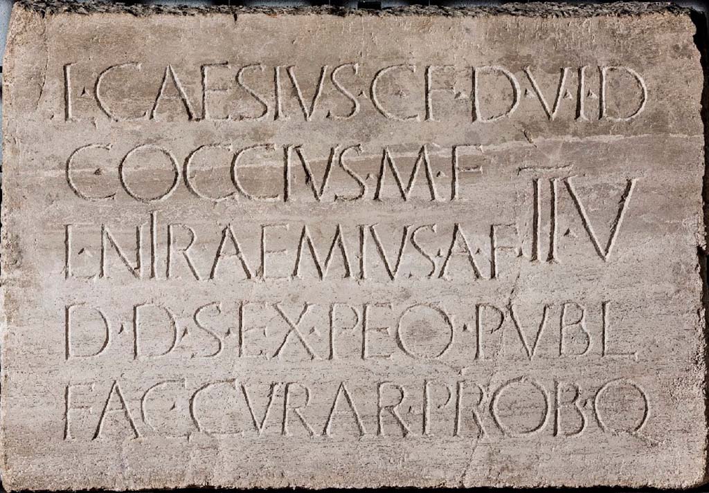 VII.5.2 Pompeii. One of two identical inscribed travertine plaques found in different parts of the building.
Now in Naples Archaeological Museum. Inventory number 3836.
Secondo Fiorelli: Un titolo ripetuto in due lastre di travertino, rinvenute nell'ambito dell'edificio, ma in luogo diverso da quello ove prima erasi collocato, ne die i nomi del duomviro e degli edili che presiedettero all'opera, fatto per decreto dei decurioni a pubbliche spese:

According to Fiorelli: A title repeated in two travertine slabs, found within the building, but in a different place from the one where it was previously located, the names of the duumvirs and of the aediles who presided over the work, carried out by decree of the decurions at public expense.

L CAESIVS C F D V I D
C OCCIVS M F      IIV
L NIRAEMIVS A F 
D D S EX PEQ PVBL
FAC CVRAR PROB Q.

According to Epigraphik-Datenbank Clauss/Slaby (See www.manfredclauss.de) this expands to read

L(ucius) Caesius C(ai) f(ilius) d(uum)v(ir) i(ure) d(icundo)
C(aius) Occius M(arci) f(ilius)
L(ucius) Niraemius A(uli) f(ilius) IIv(iri)
d(e) d(ecurionum) s(ententia) ex pe<c=Q>(unia) publ(ica)
fac(iendum) cura(ve)r(unt) prob(averunt)que      [CIL X 819]

